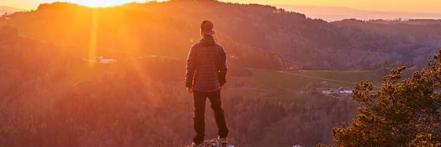 Foto: Steyr und die Nationalpark Region/Sieghartsleitner: Sonnenuntergang Wanderer genießt stimmungsvollen Sonnenuntergang am Landsberg